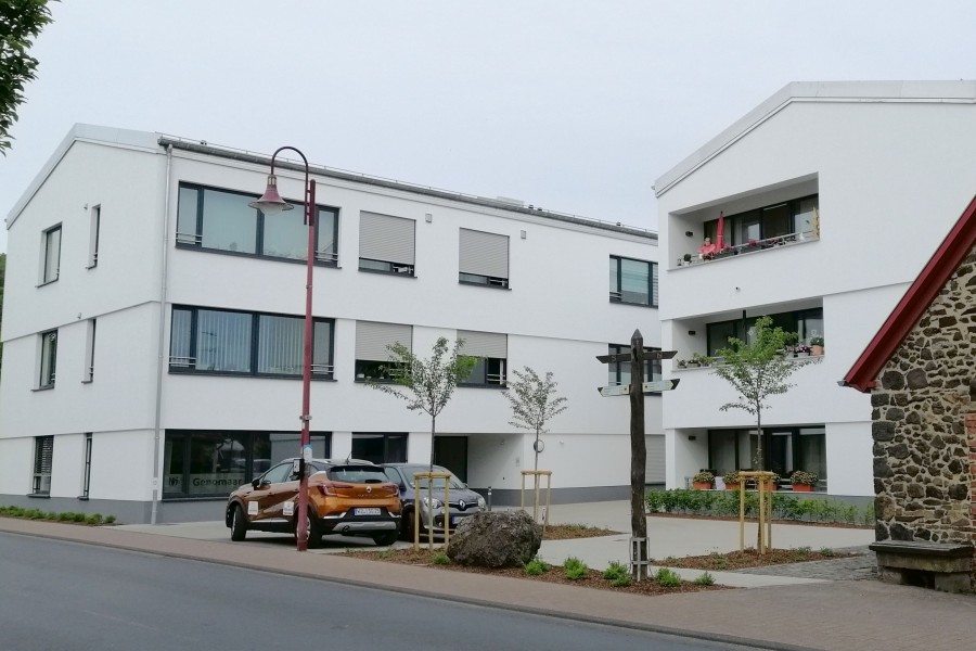 Blick von der Straße auf die zwei Wohngebäude mit weißer Fassade des Florinshofs