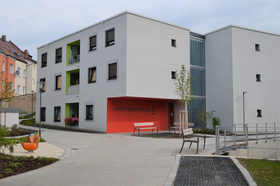 Gebäudeecke mit Rücksprung und roter Fassade im Erdgeschoss