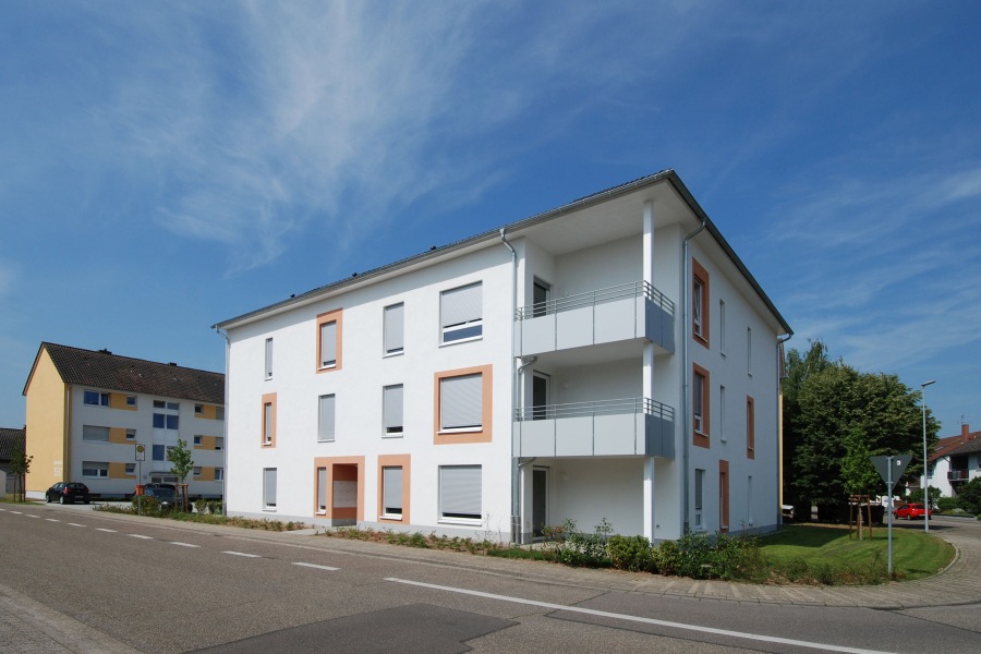 Blick von der Straße auf die Gebäudeecke des dreigeschossigen Wohngebäudes mit Balkonen
