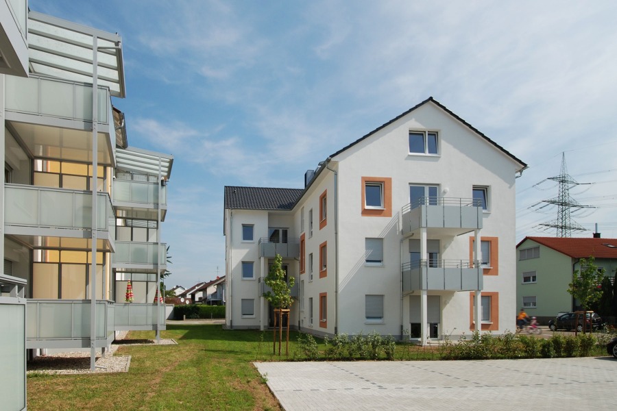 Blick auf die Giebelseite mit Stellplätzen im Vordergrund