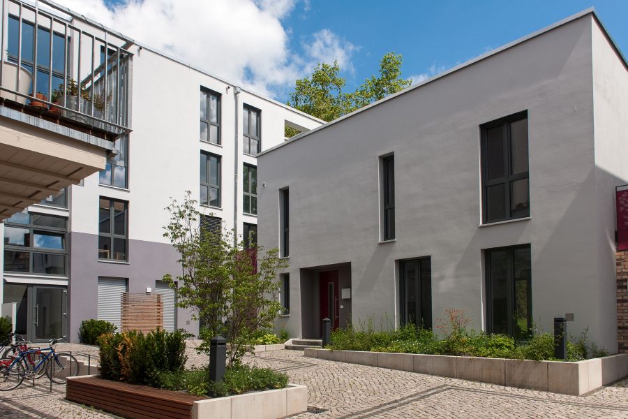 Ansicht der neuen Gebäude vom Hof mit Grünflächen